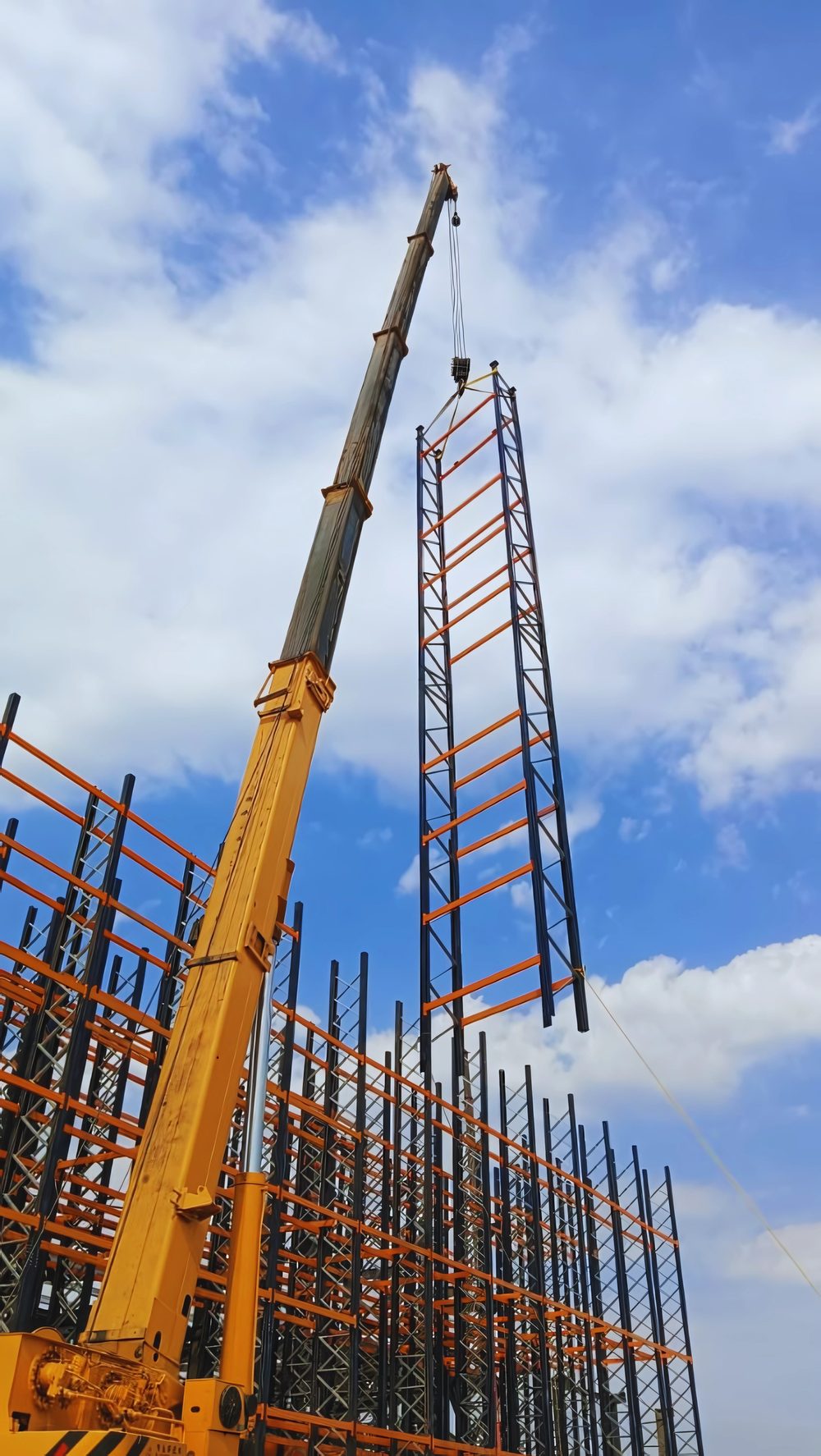 Crane lifting a steel rack tower into place at an NVEW installation site